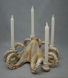 an octopus candle holder with four candles in it's center and two smaller ones on the other side