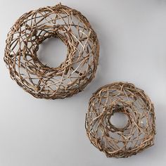 two wicker baskets sitting next to each other on a white surface with no one around them