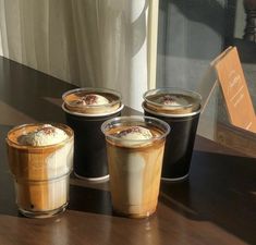 three cups of coffee sitting on top of a table