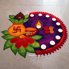 a colorful rangdi design with candles on the floor