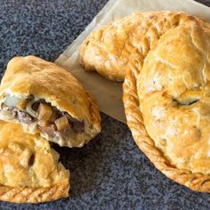 two pies sitting on top of a piece of parchment paper next to each other