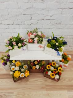 flowers are arranged in flower boxes on a table