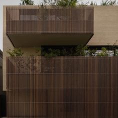 a tall building with wooden slats on the side and trees growing out of it