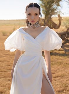 a woman in a white dress standing outside