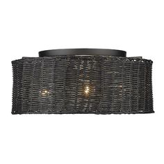 a light that is on the side of a wall mounted fixture with wicker shades