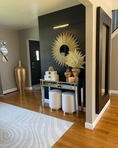 a living room filled with furniture and a large mirror on the wall over a table