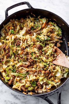 an iron skillet filled with cabbage and meat