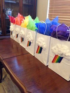 several bags with rainbows and clouds on them sitting on top of a wooden table