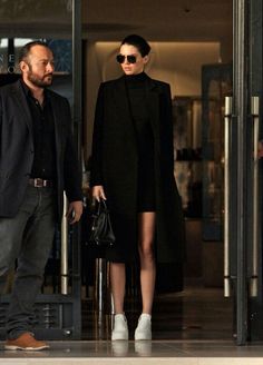 a man and woman walking out of an airport