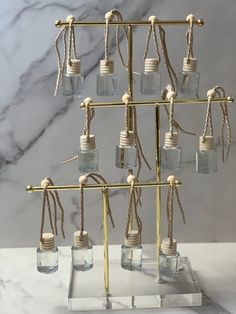 a set of six glass jars with rope hanging from the top and bottom, on a marble surface