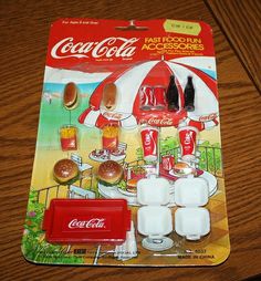 a toy coca - cola machine and other items on a table