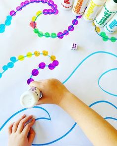 a child's hands painting on a table with crayons