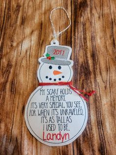 a snowman ornament hanging on a wooden surface with the words, my scarf holds it's very special you see for when it's unravel