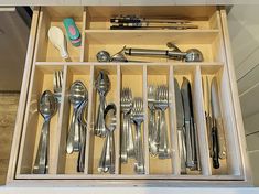 a drawer filled with silverware and utensils