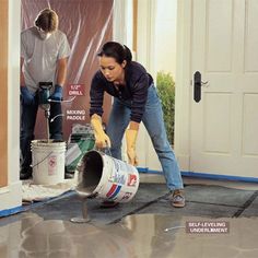 two people are painting the inside of a house with paint rollers on the floor