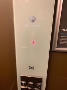 an all in one device is mounted on the wall next to a sign that says schndler