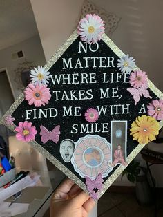 someone is holding up a graduation cap that says no matter where life takes me, find me with a smile