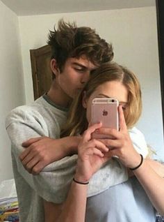 a man and woman taking a selfie in front of a mirror