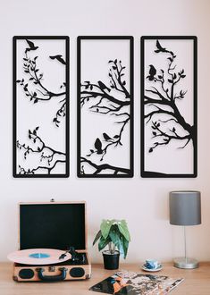 a desk with a record player and two paintings on the wall