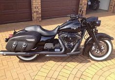 a black motorcycle parked in front of a garage