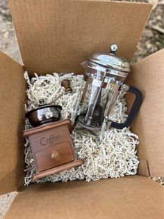 an open box with some coffee in it and a grinder on the inside that says coffee