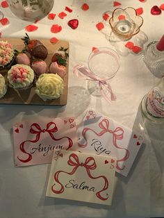 some cupcakes are sitting on a table next to wine glasses and other items