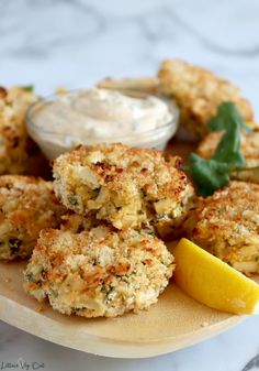 crab cakes on a plate with lemon wedges next to it and the words hearts of palm crab cakes