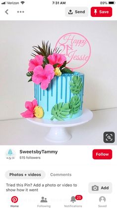 a blue cake with flowers on top and the words happy 1st birthday written in pink