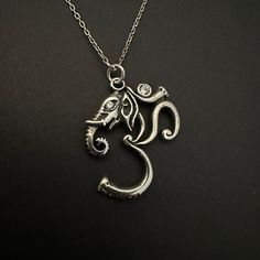 Elephant OM Symbol Necklace, Ganesha Pendant, 925 Sterling Silver Yoga Charm, Sacred Hindu Symbol, Mantra Pendant, Spiritual Jewelry  Elephant OM Charm  ॐ OM symbolizes the Universe and the ultimate reality. ॐ The syllable OM is composed of the three sounds a-u-m, which represent several important triads: the three worlds of earth, atmosphere, and heaven; thought, speech, and action; the three qualities of matter (goodness, passion, and darkness) ♥ %30 off when you purchase 2 items together. Item Details, ✔️ Made of certified 925 sterling silver ✔️ Oxidized Silver ✔️ Height of the pendant is 2.5 cm (0.98 inches) ✔️ Zircon Stones are used on the pendant ✔️ You can order the pendant with chain or without chain ✔️ Free, Express, and Insured Shipping You can check out more jewelry from NorseJe Sterling Silver Temple Jewelry For Meditation, Silver Spiritual Necklaces For Festivals, Spiritual Silver Necklaces For Festivals, Symbolic Sterling Silver Necklaces For Festivals, Hindu Symbol, Hindu Symbols, Abstract Necklace, Ganesha Pendant, Om Charm