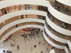 an overhead view of people walking around in a building with large circular white walls and columns