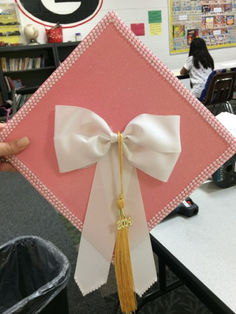 graduation cap idea: girly bow Cute Cap Designs, Caps And Gowns Decoration, Grad Caps With Bows, Esthetician Grad Cap, Graduation Cap Ideas Simple, Pink Cap For Graduation, Simple Graduation Cap Ideas College