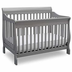 a gray crib with white sheets on the bottom and side rails, in front of a white background