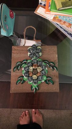 a person standing next to a wooden board with beer bottle caps on it's bottom