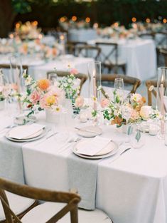 the table is set with white and pink flowers