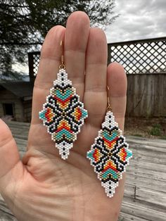 These diamond shaped geometric earrings are sure to be a crowd pleaser. They are made with the highest quality Japanese miyuki delica seed beads and are hanging from 18k gold plated earwires. Don't hesitate on your purchase..you won't be sorry. Ships from East Tennessee  Total length of each earring 3 1/4" Width of each earring 1 1/4" Weight of each earrings 2.72 grams Note To Shoppers  All jewelry is handmade by me. I personally inspect each bead before it is used in my jewelry. I put my love a Bohemian White Geometric Earrings, White Bohemian Geometric Earrings, White Geometric Bohemian Earrings, Bohemian Geometric Beaded Earrings, Multicolor Beaded Geometric Earrings, Geometric Beaded Earrings For Gifts, East Tennessee, Crowd Pleaser, Wedding Jewelry Earrings