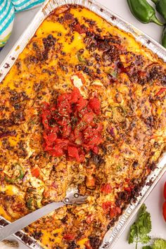 a casserole dish with tomatoes and other vegetables on the side, ready to be eaten