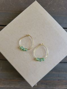 Stunning natural green crystal earrings with radiant crystal stone on gold metals. These earrings are made from petite crystals in shades of green with hues of jade that shimmer in every light setting. Beautiful natural green earrings that make the perfect gift ♡ Be sure to check out the GREEN EARRINGS section at EarringsbyLCreations for all beautiful green colored earrings available! https://www.etsy.com/shop/EarringsByLCreations?section_id=28420993 Made with quality materials and always nickel and lead free metals. Naturally colorful jewelry made by hand to complement your beauty.  Perfect gift for a friend or loved one: All jewelry pieces are packaged in jewelry boxes, wrapped in burlap ribbons and gold twine thread. Rustic wrapping for gift ready giving. Personalized gift messages avai Green Hoop Earrings With Tiny Beads, Green Adjustable Wire Wrapped Beaded Earrings, Elegant Handmade Green Crystal Earrings, Green Czech Glass Beaded Earrings, Wire Wrapped, Hoop Earrings Handmade, Colored Earrings, Green 14k Gold-filled Dangle Earrings, Dangle Earrings Gold, Crystal Hoop Earrings