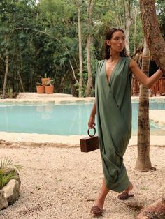 Designed with your utmost comfort in mind, the Sayo Kaftan Dress features a harmonious blend of linen, viscose, polyester, and cotton fibers. The linen brings its signature breathability, durability, and natural texture, while the viscose adds a touch of fluidity and softness, creating a fabric that feels sumptuously smooth against your skin. Its criss-cross drapery is reminiscent of the best seller Tibara Kaftan but this time, as a laid back casual look. - Full-length, sleeveless, front snap cl Kaftan Jumpsuit, African Luxury, Andrea Iyamah, Kaftan Designs, Kaftan Dress, Natural Texture, Best Seller, Matching Sets, Criss Cross