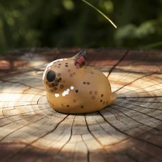 a small ceramic animal sitting on top of a tree stump