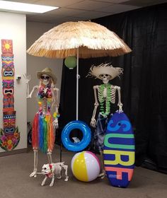 two skeletons are standing under an umbrella and other decorations