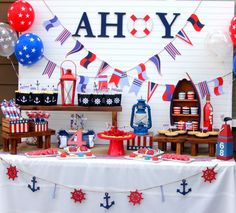 a table with red, white and blue decorations on it in front of a house