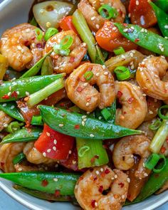 stir fry with shrimp and vegetables in a white bowl on top of a blue table