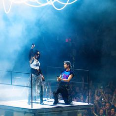 two men standing on stage in front of a crowd