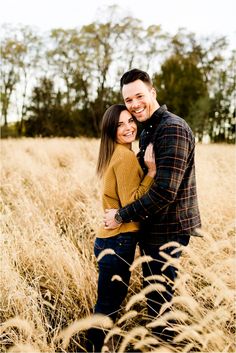 a man and woman hugging in tall grass