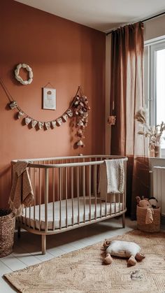 a baby's room with an orange wall and white crib