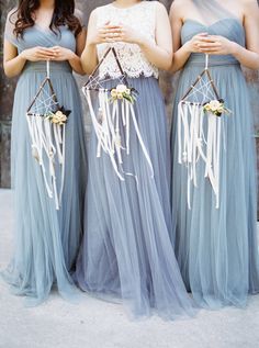 three women in long dresses standing next to each other