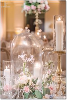 the table is set with candles, flowers and wine glasses for an elegant wedding reception