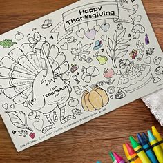 a thanksgiving coloring book with markers and crayons on the table next to it