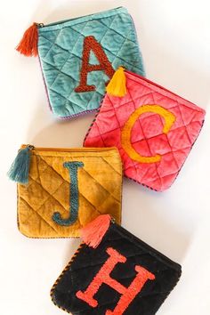 three small purses with letters on them