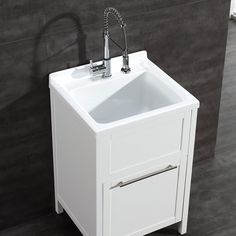 a white bathroom sink sitting next to a gray wall